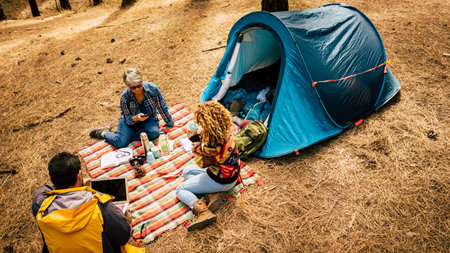 People enjoy free camping in the pines forest using technology laptop and mobile phoner and relaxed...