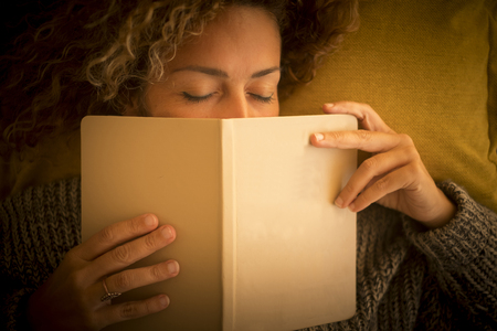 Nice lady sleep at home on the couch with 2019 diary covering his face. closed eyes and above view for people tired sleeping in peace - beauty warm autumn atmosphereの写真素材