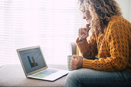 Young woman at home work with technology internet connected laptop sit down on the sofa for alternative freelance digital nomad office concept - enjoy lifestyle and business in modern wayの写真素材