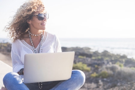 Technology and travel. Working outdoors. Freelance concept. Pretty young woman using laptop  outdoor...