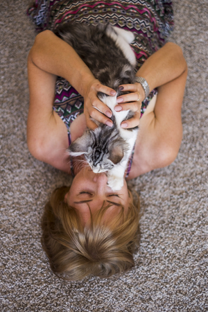 young woman with cat on her faceの写真素材