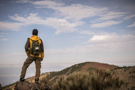 Lonely man in trekking adventure discover activity at the mountain with backpack - hiker looking the landscape and anjoying the wild undiscovered nature - beautiful environment for alternative vacationの写真素材