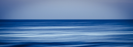 artistic image with blurry and stretched ocean blue water in long exposure with movement - perfect background for water conceptの写真素材