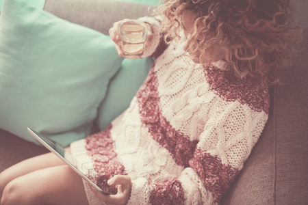 above view woman with tablet with vintage colors ping style - bright image middle age female with technology at home enjoying internet and watching a movie alone sit down on the couchの写真素材