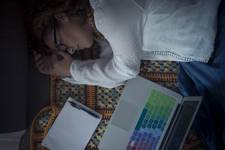 night shot and situation with tired woman worker sleeping on the sofa at home with open laptop and white paper empty of notes - stress and technology work addicted - unhappy conceptの写真素材