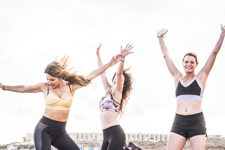 Three caucasian girls doing exercise and fitness on the beachの写真素材