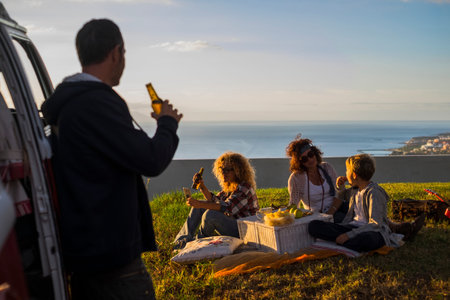 picnic and travel concept for family caucasian people enjoying the sunset sitting in the meadow and...
