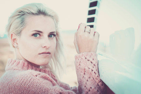 defocused portrait with focus on clear eye of a beautiful caucasian russina girl model young sit down and looking to you on camera. little smile relaxed for lifestyle conceptの写真素材