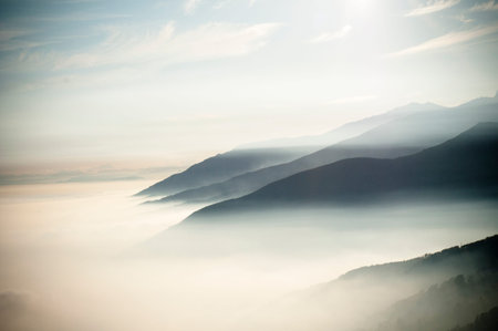 early morning at the top of the mountains looking an amazing scenery panorama with clouds like fog...