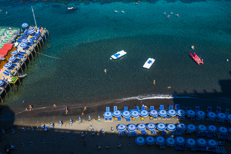 Top view of beach and blue umbreallas and sea in Italy Sorrento beautiful beach and water. boats and tourist swimming and enjying the vacation near Naples in italy. Relaxing in holiday summerの写真素材