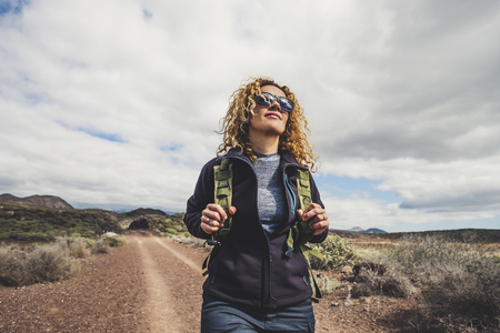 Young beautiful woman with backpack and trekking clothes hiking in the mountains. Concept healthy and active lifestyle. Female on nature background with rocky background . adventure and travel leisure activityの写真素材