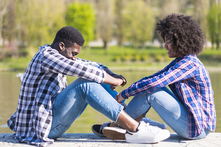 Black girl and boy enjoy and have fun together in outdoor leisure activity near a park - millennial young people in friendship - casual hipster clothes - Coloured afro couple laughing a lotの写真素材