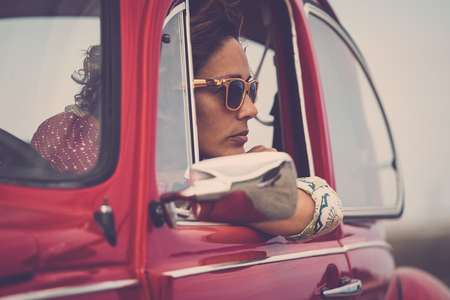 Serious caucasian lady looking outside her car with thoughts - people thinking stressed - insurance concept for women drivers - travel and lifestyle middle ageの写真素材