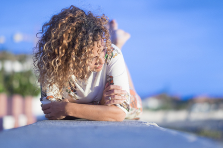 Relaxed lay down lady enjoying the day - focus on face - middle age woman in outdoor leisure activity - cold tones image - vacation conceptの写真素材