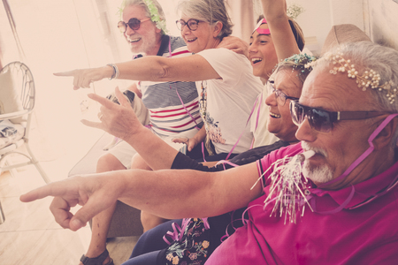 Family group of caucasian people having fun at home celebrating carnival or birthday all together in friendship with love - mixed ages people laughing and celebrating conceptの写真素材
