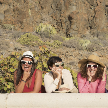 Happiness concept with three young friends women together with hats and sunglasses in summer day laughing and having fun - cheerful female people caucasian - summer and vacationの写真素材