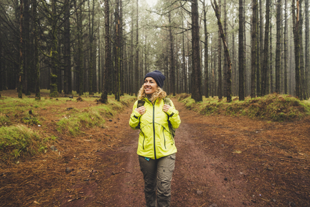 Happy woman hiking and enjoying the nature in a forest pinesの写真素材