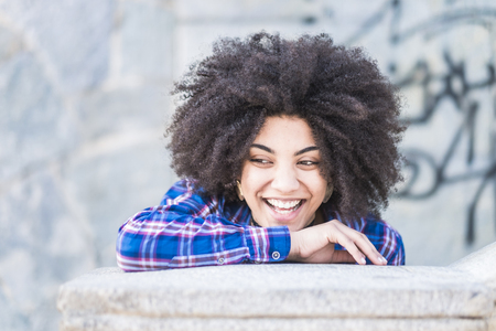 Young beautiful african hair young woman laughing and enojying in outdoor city place - cheerful hipster girl laugh and live with joy - female portrait with african hairstyleの写真素材