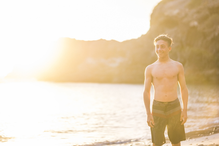 Happy young man in swimsuit smiling and having fun at the sea.の写真素材