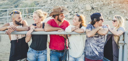 Group of young friends standing and looking each other having fun for friendship - summer and millennial alternative people outdoor smiling and laughing with love - three couples enjoying the dayの写真素材