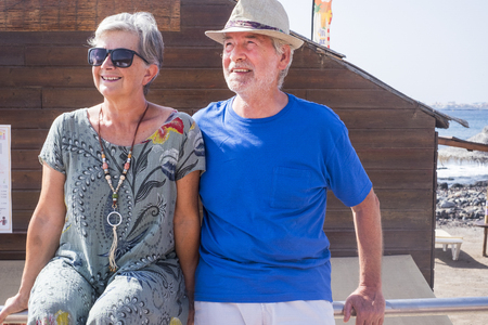 Senior couple in summer holday vacation together enjoying the outdoor leisure activity looking at the sun - together forever life for aged man and woman - tourism and touristic conceptの写真素材
