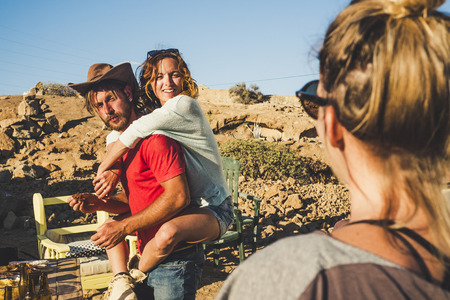 Funny and sunny day for couple with friends having fun together playing - man carry cheerful woman outdoor in rural alternative vacation outdoor leisure activity placeの写真素材