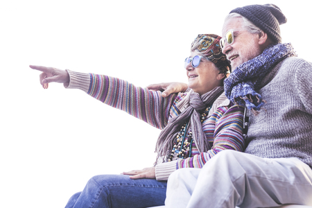 Happy cheerful people old senior caucasian couple smile and hug toegether with love and nice retired lifestyle outdoor leisure activity - white clear sky in backgroundの写真素材