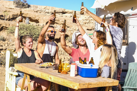 Group of caucasian people drink together outdoor. Bottle of beer and happinessの写真素材