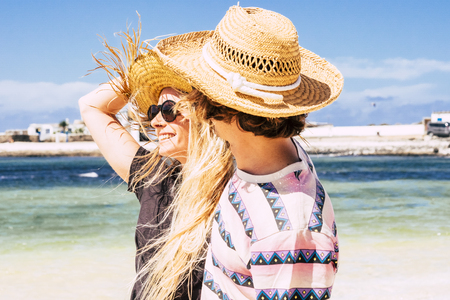 Cheerful happy couple enjoy the summer holiday vacation together in tropical place with blue sea and sky in background - People having fun and love in outdoor leisure activityの写真素材
