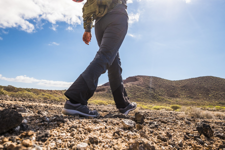 Unrecognizable people lady doing trekking outdoor sport activity in the mountains viewed from back - backpack adventure and enjoying nature - freedom and alternative vacation conceptの写真素材