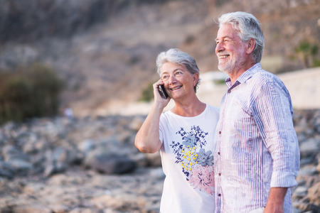 Happy cheerful aged old caucasian couple enjoy and have fun together in outdoor - together forever life concept for beautiful man and woman retiredの写真素材