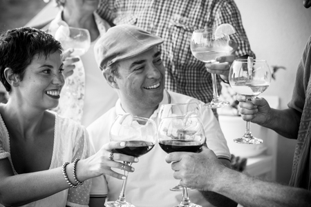 Black and white friendship people concept with couple and friends together toasting and cheering with wine red and cocktails - celebration concept  with caucasian man and womanの写真素材
