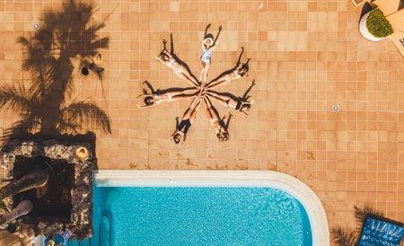 Vertical top view of group of women young friends compose a star together with their bodies -...