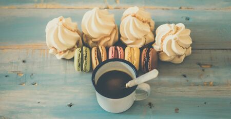 Vintage style sweet breakfast concept with coffee and macarones biscuits little cakes on a blue wooden background viewed from above - food and sweet biscuits - sugar power lifestyleの写真素材