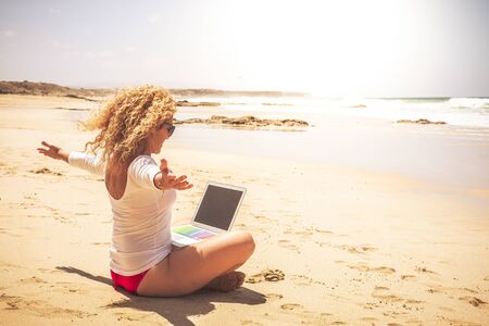 Joyful and happiness job related for young modern people working out of office frree in the world - successful beautiful woman with computer laptop connected at the beach with sea viewの写真素材