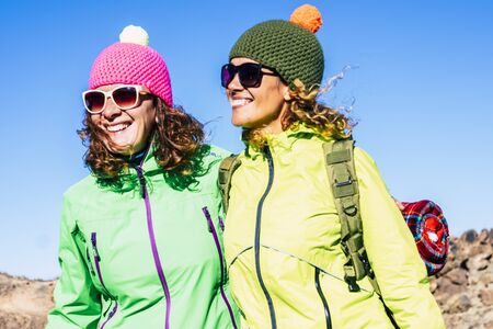 Nice people couple of cheerful adult beautiful woman in outdoor leisure activity together in friendship - trekking and hiking at the mountain for healthy lifestyle females friendsの写真素材