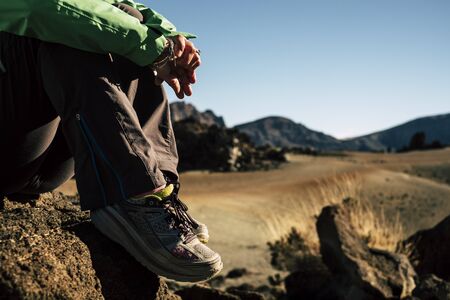 Close up of shoes hiker resting and relaxing during outdoor trekking leisure activity at the mountain - equipment for hike and enjoy the outdoors - defocused valley in backgroundの写真素材