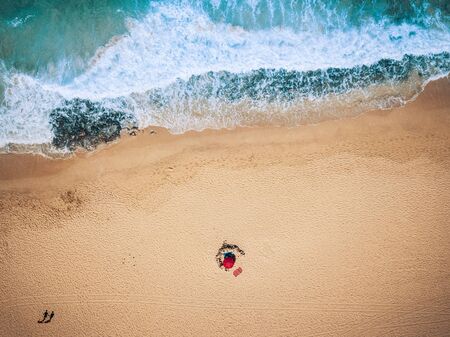 Aerial view of ocean waves and sand beach with tourists walking - summer holiday vacation concept with people - blue and yellow colors - tropical scenic place with nice nature and outdoorsの写真素材