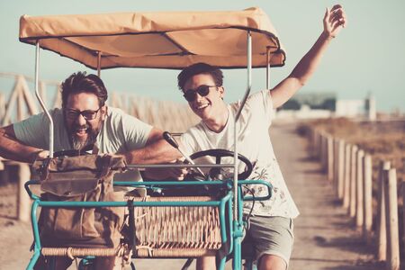 People having fun together with family father and son different ages laughing and enjoying a summer bike - vintage colors filter - happiness and joyful concept with young and adult menの写真素材