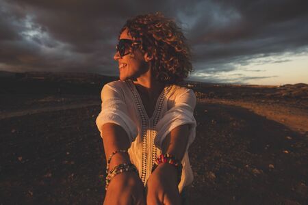 Cheerful happy people beautiful caucasian young woman turn fast and laugh a lot during dark evening sunset time - happiness and joyful emotions conceptの写真素材