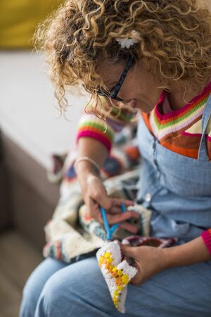 Artistic creative caucasian woman at home doing artwork and artcraft handmade - indoor leisure activity with textile fabric and colors - joyful lifestyle peopleの写真素材