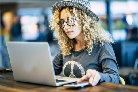 Beautiful young woman working with roaming phone device like digital travel nomad or smart work at...