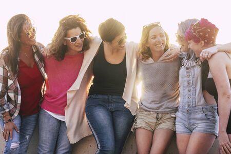 Group of adult and young caucasian friends enjoy together in friendship without social distance in freedom - beautiful mixed generations women have fun together outdoorの写真素材