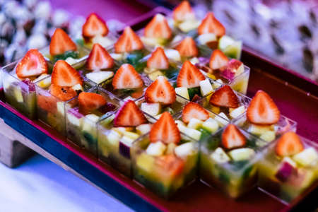 Close up of healthy and fresh seasonal little portion. cakes with strawberry and other fruits for wedding or party catering job - colorful food background imageの写真素材