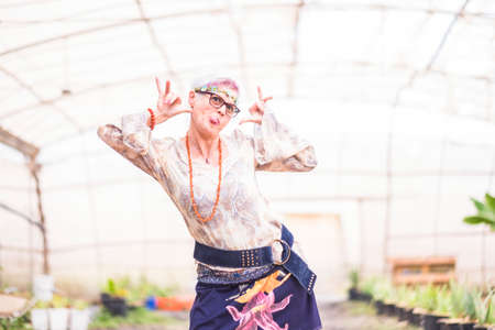 Cheerful happy senior white hair woman smile and pose for hippy clothes portrait - happiness and colorful lifestyle for alternative people outdoor - trendy fashion dressの写真素材
