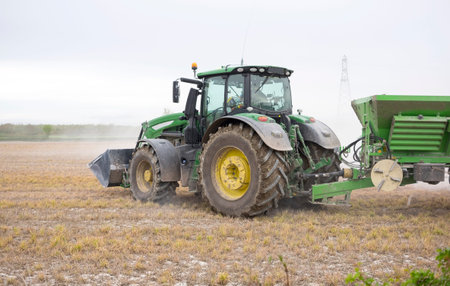 Tractor spreading powder fertilizer on a field
