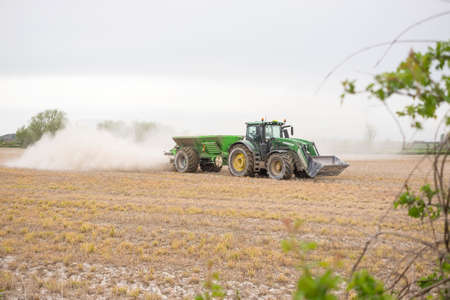 Tractor spreading powder fertilizer on a fieldのeditorial素材