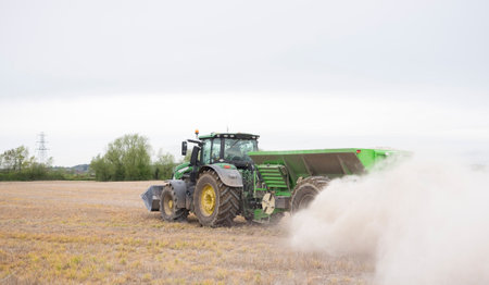 Tractor spreading powder fertilizer on a fieldのeditorial素材