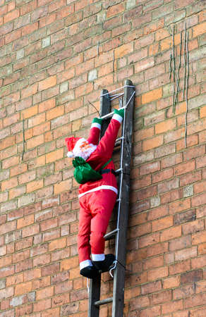 An inflatable Santa Claus figure on a ladderの写真素材