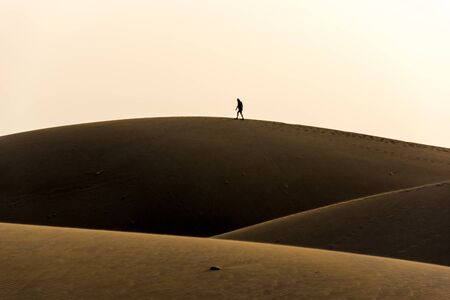 Men walking in the desert of gran canaria, spainの写真素材